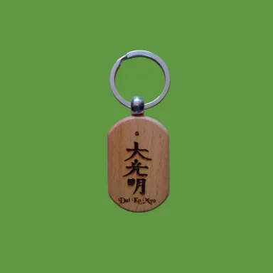 Llave con un colgante de madera grabado con caracteres chinos sobre fondo verde.