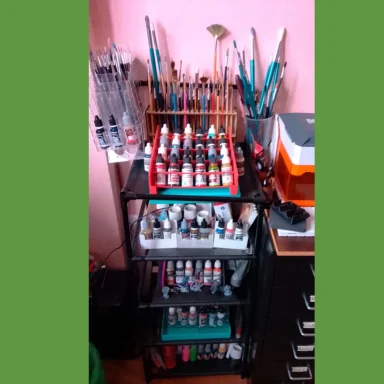 Estante con pinturas, pinceles y diversos materiales de arte organizados.