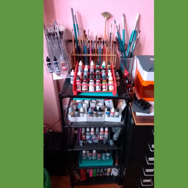 Damos vida a tus diseños Estante con pinturas, pinceles y diversos materiales de arte organizados.